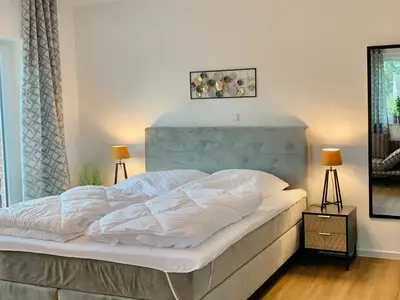 Geräumiges Schlafzimmer mit Doppelbett und Nachttischen.