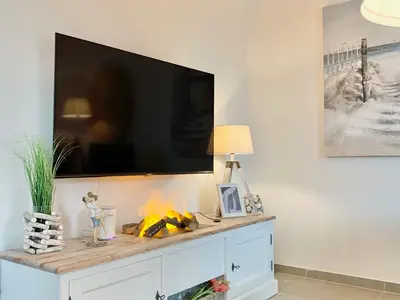 Innenansicht eines Wohnzimmers mit Fernseher und Beleuchtung.