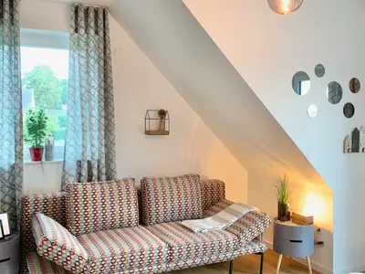 Gemütlicher Wohnraum mit Sofa und Fenster.