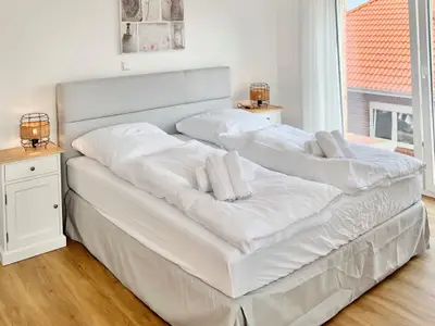 Schlafzimmer mit zwei Einzelbetten und Nachttischen.