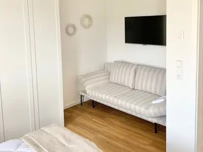 Gemütlicher Wohnbereich mit Sofa und Fernseher.