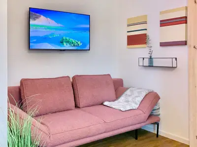 Gemütliches Wohnzimmer mit Sofa und Fernseher.