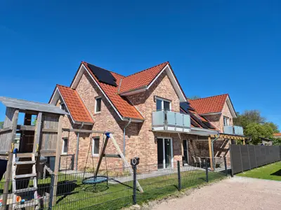 Außenansicht eines modernen Ferienhauses mit Spielplatz