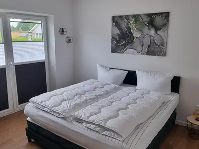 Schlafzimmer mit Doppelbett und Aussicht