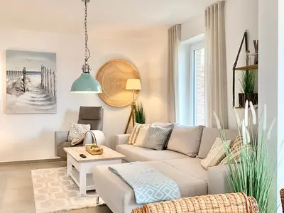 Helles Wohnzimmer mit Sofa, Tisch und dekorativen Elementen.