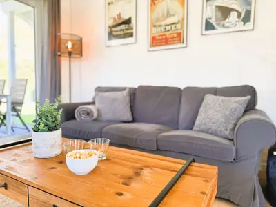 Wohnzimmer mit Couch, TV und Holzofen