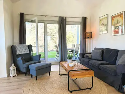 Wohnzimmer mit Couch, TV und Holzofen