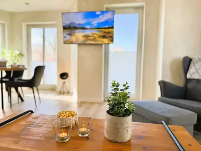 Wohnzimmer mit Couch, TV und Holzofen