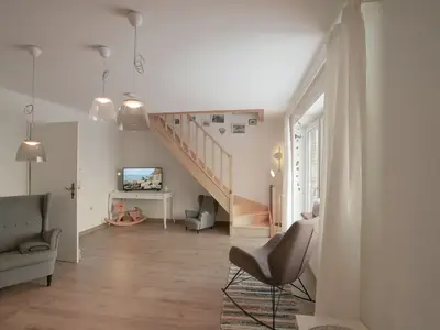 Heller Wohnraum mit Treppe und Fernseher