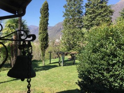 Blick vom Hauseingang über den Garten auf die Kirche von Verscio