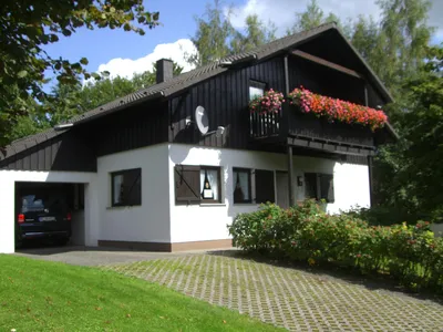 Hausfront mit Parkplätzen