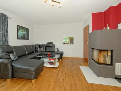 Wohnzimmer mit Ledercouch und Kachelofen