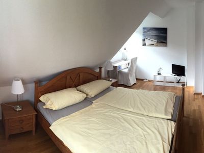 Schlafzimmer mit Doppelbett, Kleiderschrank, Schreibtisch und TV