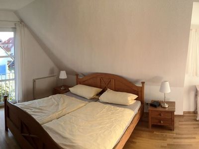 Schlafzimmer mit Doppelbett, Kleiderschrank und Schreibtisch