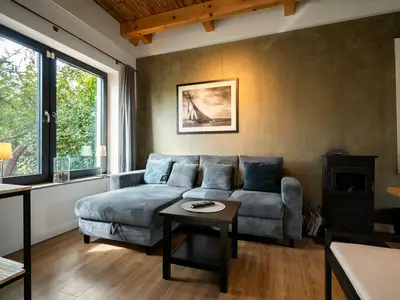 Ferienhaus Große Sommerliebe Waren (Müritz) - Gemütliches Wohnzimmer mit moderner Couch und großem Fenster