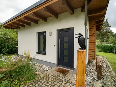 Ferienhaus Kleine Sommerliebe Waren (Müritz) -  Moderner Eingangsbereich mit Garten und dekorativem Metallvogel
