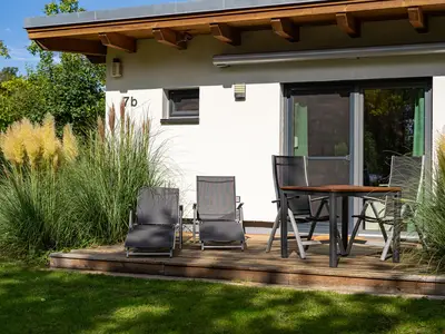 Ferienhaus Kleine Sommerliebe Waren (Müritz) - Sonnige Holzterrasse mit Gartenmöbeln und Liegen