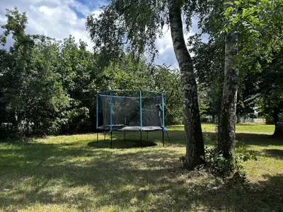 Garten mit Trampolin, Schaukel, Rutsche und Spielbauwagen