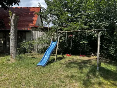 Garten mit Trampolin, Schaukel, Rutsche und Spielbauwagen