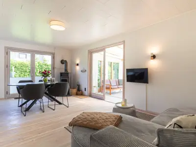 Wohnzimmer mit TV-Ecke, Esstisch und Ofen