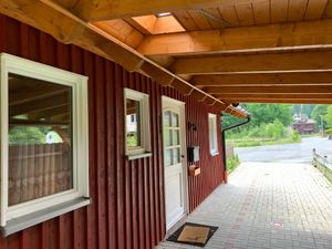 Außenansicht des Gebäudes. Eingangsbereich mit Carport