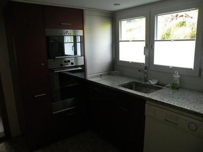 Küchenteilansicht mit Backofen und eingebauter Mikrowelle, im Vordergrund rechts der Geschirrspüler