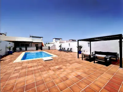Entspannungsbereich im Freien: Gemütlicher, schattiger Lounge-Bereich am Pool.