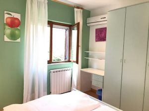 Das Schlafzimmer mit Kleiderschrank, Schreibtisch und Klimaanlage