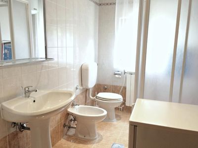 Das Badezimmer mit Dusche, WC, Waschbecken, Bidet, Spiegel und Waschmaschine