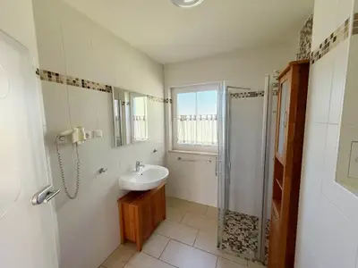 Badezimmer mit Dusche und Waschbecken