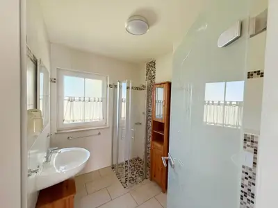 Badezimmer mit Dusche und Waschbecken