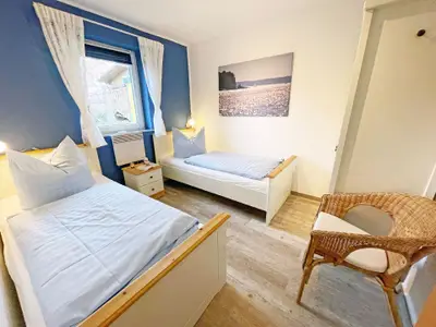 Gemütliches Schlafzimmer mit Leselampen, abdunkelbarem Fenster mit Fliegengitter.