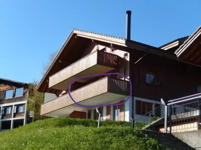 Grosszügiger Balkon mit Tisch, Stühlen und Sonnenschirm