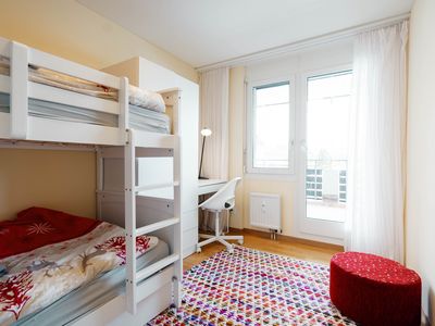 Das Kinderzimmer ist eingerichtet mit einem Etagenbett und Schreibtisch.