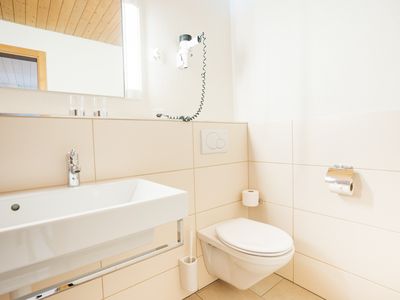 Das Badezimmer ist ausgestattet mit Waschbecken und WC.