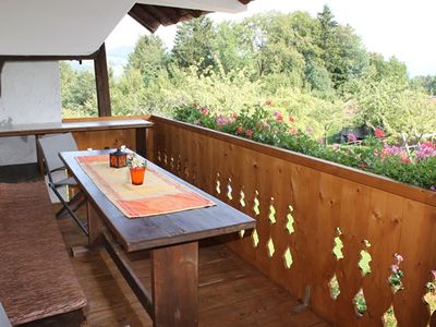 Geräumiger Balkon mit Sitzgelegenheit aus Holz und Bergblick