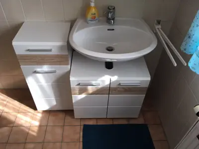 Das mit neuen Möbeln ausgestattete Bad ist hell und freundlich