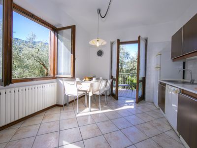 Die Küche mit Esstisch für 6 Personen und Ausgang auf den Balkon