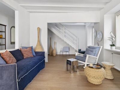 Wohnzimmer mit Schlafsofa im Hintergrund Treppe zum Schlafzimmer