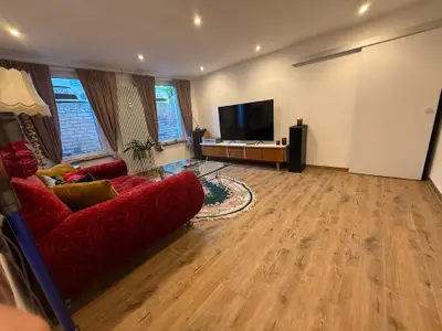 das gemütliche Wohnzimmer mit großer Couch und modernen Ambilight-TV mit Netflix  & Co ...