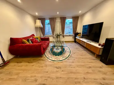 das gemütliche Wohnzimmer mit großer Couch und modernen Ambilight-TV mit Netflix  & Co ...