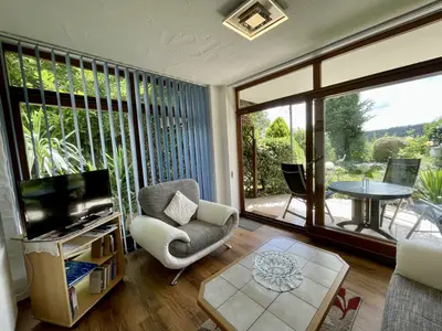 im Wintergarten - Wohnbereich mit gemütlicher Couch + Sessel, Südterrasse mit herrlichen Ausblick in den Garten.