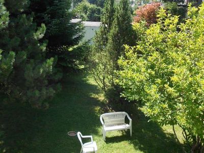 Großer parkähnlicher Garten mit Rasen, Bäumen und Blumen der Jahreszeit entsprechend.