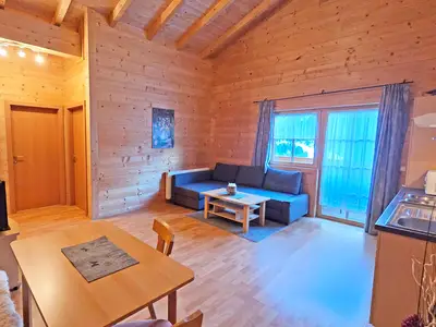 Wohnküche mit Couch und Flat TV