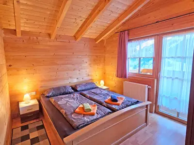 Schlafzimmer mit Doppelbett und Ausgang zum Balkon