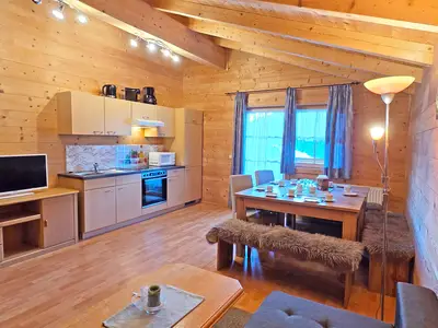 Wohnküche mit Couch, Sitzgelegenheit und Flat TV