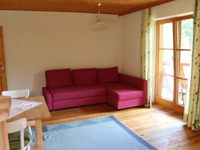 Wohnraum mit Couch, Zugang zum Balkon