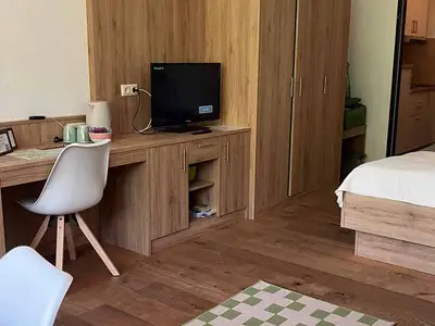 Schreibtisch & TV sowie Bett in der Ferienwohnung Jogginghose