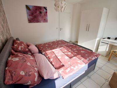 Ferienwohnung Rosengarten-Schlafzimmer mit Boxspringbett und Tisch