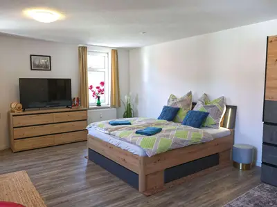 Schlafzimmer mit Schrank, Sitzecke und Fernseher
